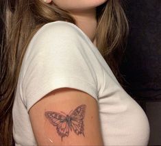 a woman with a butterfly tattoo on her arm