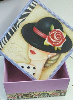 an open box with a painting of a woman wearing a hat and a rose on it