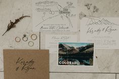 wedding stationery with rings and postcards on a marble wall in colorado, usa