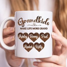 a woman holding a coffee mug with the words grandkids make life more grand