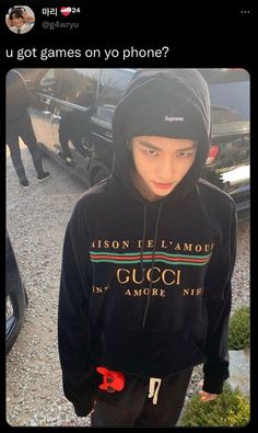 a young man standing in front of a parked car wearing a black gucci hoodie