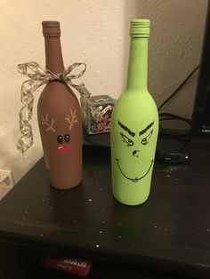 two wine bottles with faces painted on them