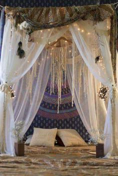 a bed covered in white curtains and lights