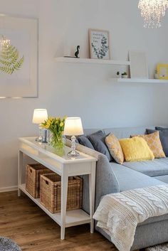 a living room filled with furniture and a white table topped with a vase full of flowers