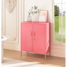 a pink cabinet in a room with a window