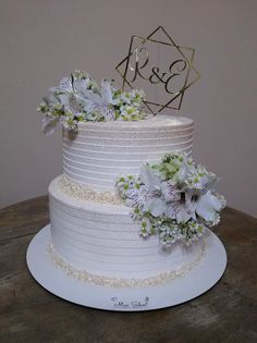 a white wedding cake with flowers on top