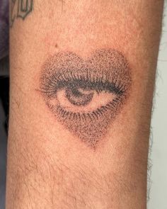 a close up of a person's arm with an eye tattoo on the side