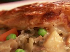 a close up of food on a plate with peas and meat in the middle,