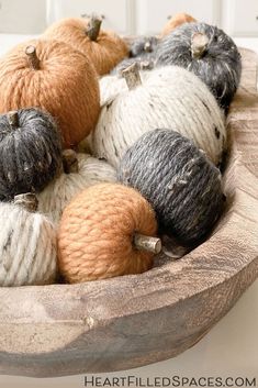 yarn balls and pumpkins in a wooden bowl