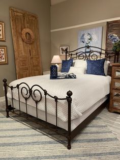 a bedroom with a bed, nightstands and pictures on the wall above it that is decorated in blue and white