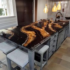 a large kitchen island with marble top and stools