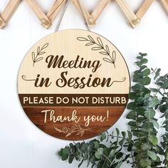 a wooden sign that says meeting in session please do not disturb thank you