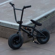 an upside down black bike sitting on the ground