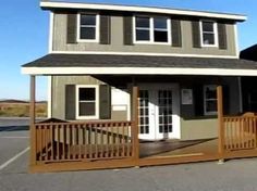 a small house with a porch and wooden railings