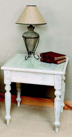 a white table with a lamp and books on it next to a carpeted floor