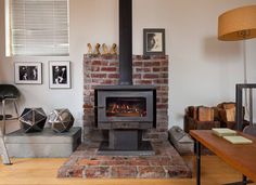 a living room with a fire place and pictures on the wall next to each other