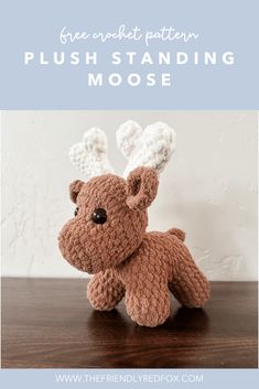 a crocheted reindeer sitting on top of a wooden table with text overlay reading free crochet pattern plush standing moose