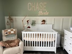 a baby's room with a crib, chair and wall decal that says chase steele