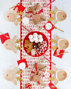 a table topped with lots of candy and candies on top of a red plate