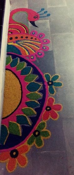 an artisticly designed rug on the floor in front of a door with flowers and peacocks painted on it