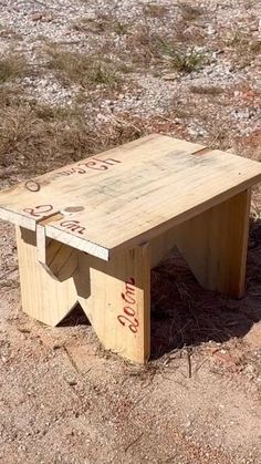 a wooden bench sitting on top of a dirt field