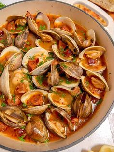 clams and chorizzo in a pan with bread on the side