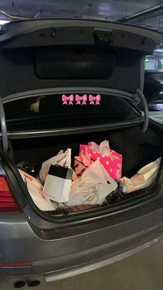 the trunk of a car is filled with bags and presents for someone to put in it