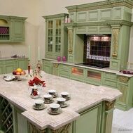 a large kitchen with green cabinets and marble counter tops on the island in front of an oven