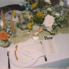 the table is set with flowers and place settings