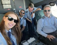 three pilots are sitting in the cockpit of an airplane and one pilot is smiling at the camera