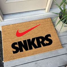 a door mat with the word snkrs on it and a red nike logo