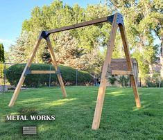 a wooden swing set sitting on top of a lush green field