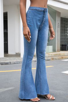 a woman in high rise jeans standing on the street