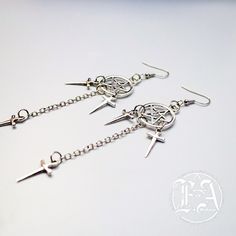 These dark and alluring Dagger Earrings. Measuring 3.5 inches in length, these alloyed earrings are perfect for adding a touch of edgy style to any outfit. Make a statement and stand out from the crowd with this must-have accessory. Punk Style Metal Dangle Hoop Earrings, Edgy Metal Dangle Hoop Earrings, Alternative Style Nickel-free Metal Earrings, Nickel-free Metal Earrings In Alternative Style, Nickel-free Metal Alternative Style Earrings, Edgy Pierced Metal Earrings, Alternative Style Dangle Earrings For Gift, Hypoallergenic Punk Dangle Earrings, Hypoallergenic Dangle Earrings In Punk Style