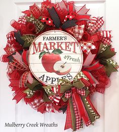 a red and green mesh wreath with an apple on it that says farmer's market fresh apples