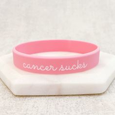 "A modern wristband to shout out against cancer. 100% silicone band (latex free). Adult size. Pink debossed handwritten message: \"Cancer Sucks\". SIZING Approx 12mm or 0.5\" wide. Approx 8 inches or 202 mm long. Fits most adults. Ideal for someone who measures up to 215 mm around the widest part of their hand. Not appropriate if you have particularly large hands. TAKING CARE - Please take care when taking your wristband on and off. Although there is a little bit of stretch in the band, keep in Personalized Bracelets For Her, Medical Alert Jewelry, Medical Alert Necklace, Coordinates Jewelry, Awareness Jewelry, Medic Alert Bracelets, Medical Bracelet, Family Jewellery