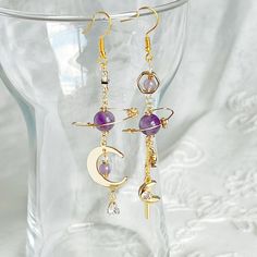 Amethyst Planet and Moon Earrings Made from the beautiful gemstone amethyst, these earrings make the perfect gift for those born in February. Boasting a delicate planet design accompanied by a luminous moon and star drop, these earrings are both versatile and eye-catching. As a gift shop, we offer a complimentary gift box for every order. Detail: Length of one earring - 75mm; size of beads - 5-8mm Material: ear wire - sterling silver; beads - natural Amethyst, Pietersite stones;  Note: the Amethyst Planet and Moon Earrings are handmade locally in the UK, each pieces would vary slightly in detail.  About postage: Standard postage When choosing standard postage, we assume this order is for yourself, or you will wrap the item yourself before giving it out as a gift (the complimentary gift box Purple Round Spiritual Earrings, Spiritual Purple Round Earrings, Spiritual Round Purple Earrings, Celestial Amethyst Moon Charm Jewelry, Celestial Amethyst Jewelry With Moon Charm, Purple Celestial Dangle Earrings, Celestial Purple Dangle Earrings, Elegant Crystal Earrings With Moon Charm As Gift, Purple Pierced Crystal Earrings As Gift