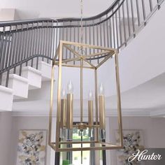 a chandelier hanging from the ceiling in front of a stair case and window