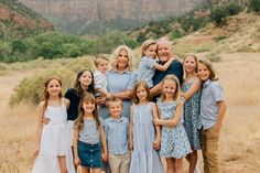 a family poses for a photo in front of the grand canyon with mountains in the background