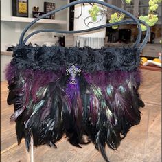 This Is A One Of A Kind Lcj Handbag Custom-Made For A Special Soire. It Is A Vintage Faux/ Suede Handbag (10 1/2x 5 1/2) That Was Embellished With Exquisite Raven Plumage And Jeweled Cross. There A Few Thick Purple Accent Feathers In The Front, That Give The Bag Dimension And Extra Thickness (About 2” At Top When Clasp Is Closed And 3” At Bottom) And Depth. Bag Measures Several Inches Longer Than Original Bare Vintage Bag, Because Of The Long Feathers In Center Front. It Is Exquisite And So Unique. Truly A Statement Piece. Purple Rectangular Bag With Dust Bag, Purple Evening Satchel Shoulder Bag, Purple Rectangular Bag, Purple Evening Bags With Removable Pouch, Luxury Purple Pouch Bag, Evening Purple Shoulder Bag With Top Carry Handle, Purple Clutch Shoulder Bag For Formal Occasions, Formal Purple Clutch Shoulder Bag, Purple Tote Shoulder Bag With Dust Bag