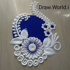 a blue and white piece of art on a wooden surface with silver filigrees