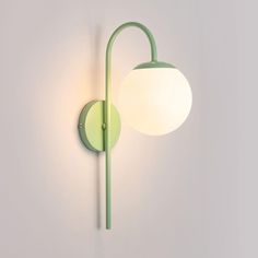 a green wall light with a white ball on it