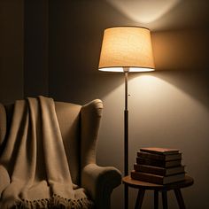 a lamp that is next to a chair and a table with some books on it