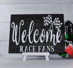 a wooden sign that says welcome to race fans with a checkered flag on it