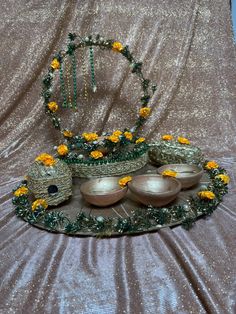 there is a decorative display with bowls and flowers on the table cloth, along with other decorations