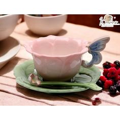 a cup and saucer on a plate with berries