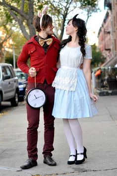 a man and woman dressed up as alice and the mad hatter on a city street