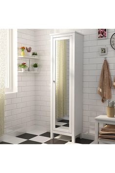 a white bathroom with black and white checkered flooring on the walls, shower stall in the corner