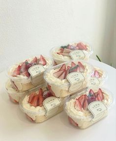 four plastic containers filled with strawberries on top of a table