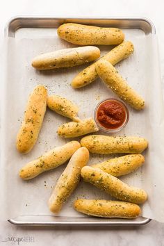 breadsticks on a baking sheet with ketchup